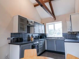 A kitchen with cabinets and appliances at Elwy Cottage in St. Asaph