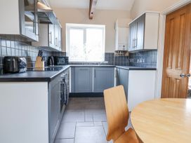 A kitchen with cabinets and table at Elwy Cottage St. Asaph