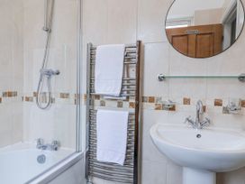 A bathroom with a bathtub, shower, and towels at Elwy Cottage, St. Asaph