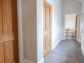 A hallway with doors and a table with chairs at Elwy Cottage St. Asaph