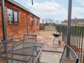 A garden with a table and chairs and a barbecue grill at Elwy Cottage St. Asaph