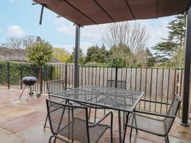 An outdoor patio with a table and chairs at Elwy Cottage in St. Asaph