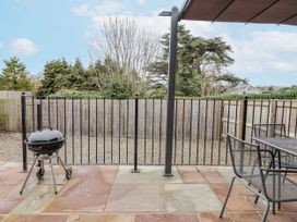 An outdoor area with a grill and table with chairs at Elwy Cottage, St. Asaph