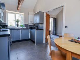 A kitchen with cabinets and a table at Elwy Cottage in St Asaph