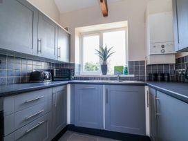 A kitchen with cabinets, a sink, and appliances at Elwy Cottage in St Asaph