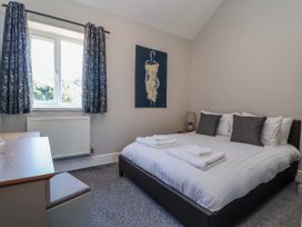 A bedroom with a bed and a desk at Elwy Cottage in St Asaph