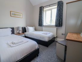 A bedroom with two beds and a desk at Elwy Cottage in St Asaph