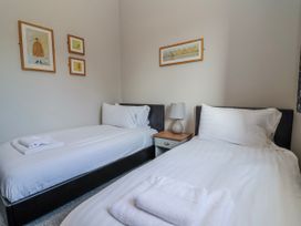 A bedroom with twin beds and a bedside table at Elwy Cottage St Asaph
