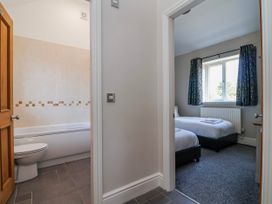 A bathroom with a bath tub and adjoining bedroom at Elwy Cottage St Asaph