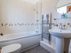 A bathroom featuring a shower above a bath at Elwy Cottage in St Asaph