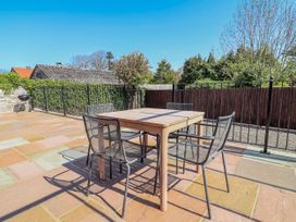 A patio with a table and chairs at Elwy Cottage St Asaph