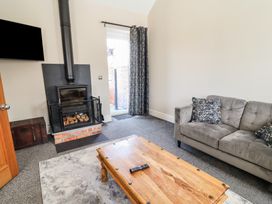 A living room with a fireplace and sofa at Elwy Cottage in St Asaph