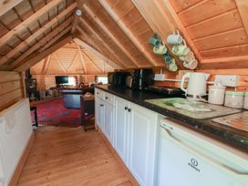 A kitchen with appliances and mugs in hooks at Antlers Lodge in Biddulph Moor
