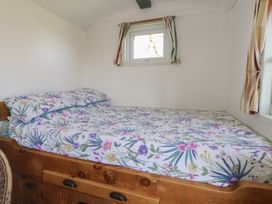 A bedroom with a bed and floral patterned sheets at Shepherds Delight in Biddulph Moor