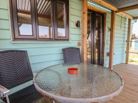 An outdoor seating area with a glass table and chairs at Golden Fleece in Biddulph Moor