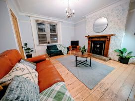 A living room with a sofa and a fireplace at 4 The Croft in Hexham