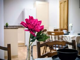 A dining room with a flower vase on a table at 4 The Croft in Hexham