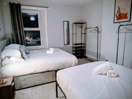 A bedroom with two beds and a window at 4 The Croft in Hexham