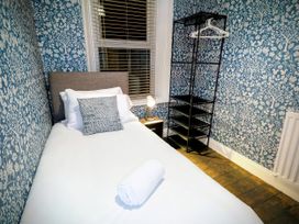 A bedroom with a bed and a shelving unit at 4 The Croft in Hexham