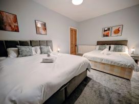 A bedroom with two beds and artwork on the walls at 4 The Croft in Hexham