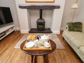 A living room with a fireplace and tea set at 3 Tre Felin Llandygai near Bangor