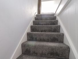 A staircase with carpet leading to a window at 3 Tre Felin Llandygai near Bangor