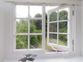A window view of a garden with a sculpture at 3 Tre Felin Llandygai near Bangor
