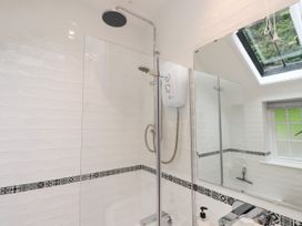 A bathroom with a shower and mirrors at 3 Tre Felin in Llandygai near Bangor