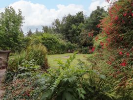 A garden with a pathway and flowering plants at 3 Tre Felin in Llandygai near Bangor