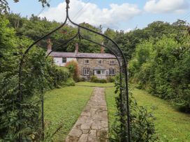 A house with a pathway leading to it surrounded by greenery at 3 Tre Felin in Llandygai near Bangor