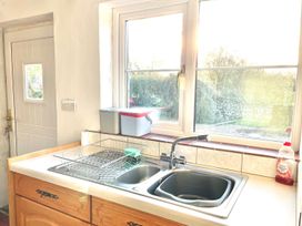 A kitchen with a sink and dish rack at Cwt Tyddyn Shepherd's Hut in Corwen