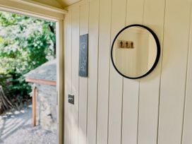A wall with a mirror and slate board at Cwt Tyddyn Shepherd's Hut in Corwen