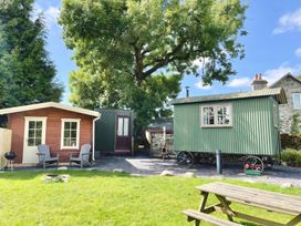 An outdoor area with a wooden cabin and a shepherd's hut at Cwt Tyddyn Shepherd's Hut Cefn Brith near Cerrigydrudion