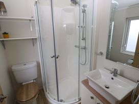 A bathroom with a shower, toilet, and sink at Wernlas Lodge in Oxwich