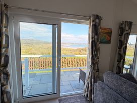 A living room with a window overlooking the landscape at Wernlas Lodge in Oxwich