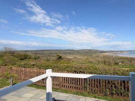 A view of landscape with water and hills at Wernlas Lodge in Oxwich