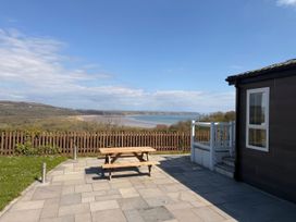 An outdoor area with a picnic table and views at Wernlas Lodge in Oxwich