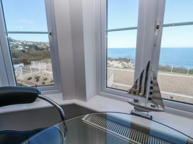 A sitting room with a boat decoration and a view of the ocean at 21 Compass Point in Carbis Bay
