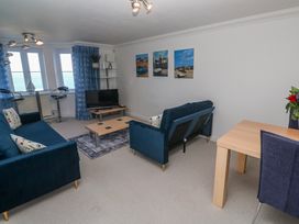 A living room with a tv and seating area at 21 Compass Point in Carbis Bay
