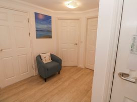 A hallway with a chair and a painting at 21 Compass Point Carbis Bay