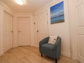 A hallway with doors and a chair at 21 Compass Point in Carbis Bay