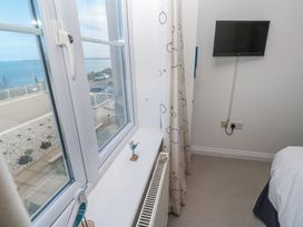 A bedroom with a window and television at 21 Compass Point in Carbis Bay