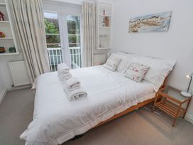 A bedroom with a double bed and shelves at 21 Compass Point, Carbis Bay