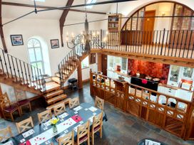 A dining room with a staircase and kitchen area at Kaber Chapel Kaber near Kirby Stephen