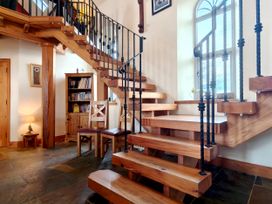 An entrance hall with a staircase and bookshelf at Kaber Chapel in Kaber near Kirby Stephen