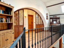 A hallway with a bookshelf and ornate wooden cabinet at Kaber Chapel in Kaber near Kirby Stephen