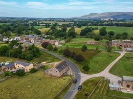 An aerial view of a rural area with houses and fields near Kaber Chapel in Kaber near Kirkby Stephen