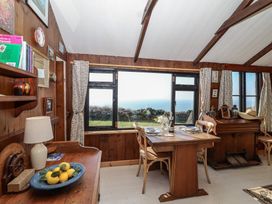 A dining room with a table and chairs overlooking the sea at The Cabin