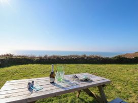 A table with drinks and a magazine overlooking the sea at The Cabin