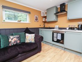A kitchen with a sofa and cabinets at Owls Nest Lodge South Molton